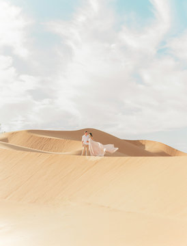 A couple in the desert standing in a dramatic pose