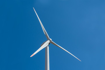 Wind turbine close up against a blue sky background
