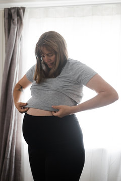 Full term pregnant woman changing clothes