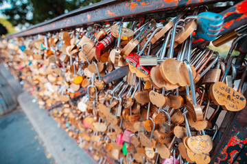 Fototapeta premium Lovers hang padlocks on bridges and fences in Paris, causing heated debate among the urban public