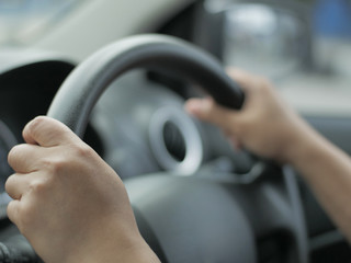 Naklejka premium Close up of Hands Driving Car Concept