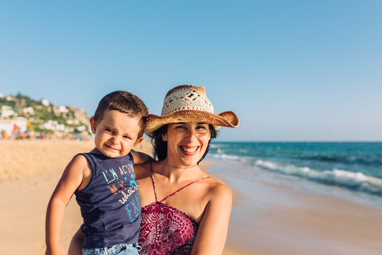 Young mother and toddler having fun by the sea.