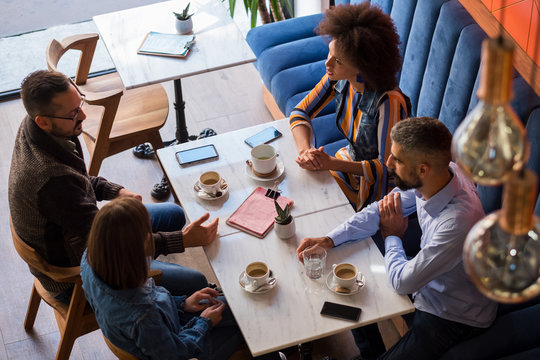 Group Of People Drinking Coffee At The Cafe