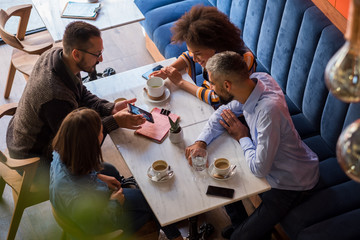 Group Of Friends At The Cafe Looking At The Phone
