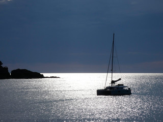 Barco velero anclado en el reflejo del sol en medio de una Bahía