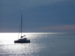 Barco velero anclado en el reflejo del sol en medio de una Bahía © Jorge