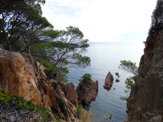 Paisaje de la Costa Brava catalana, España, con el mar azul, islas, aguas cristalinas, árboles y acantilados