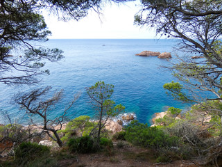 Paisaje de la Costa Brava catalana, España, con el mar azul, islas, aguas cristalinas, árboles y acantilados