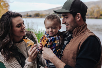 young family on fall day by the river