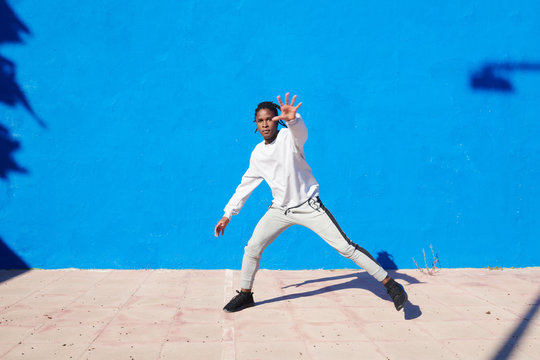 Dancing black man against blue wall