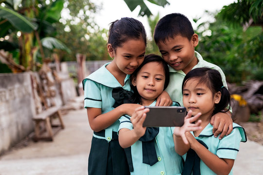 Asian schoolkids using smartphone