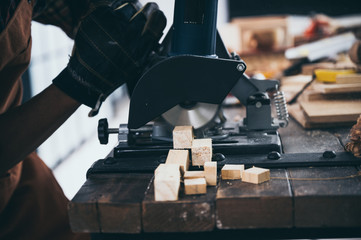 Close-up of a carpenter using a circular saw to cut a large board of wood