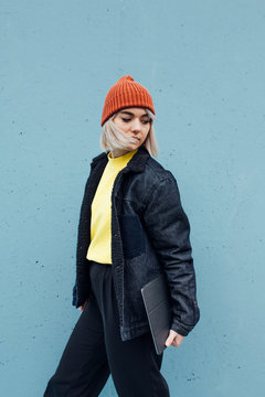 Stylish woman walking against the blue background