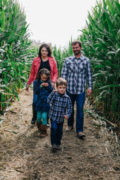 family walks together through corn maze