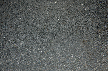 Background, water droplets on a gray glossy surface.