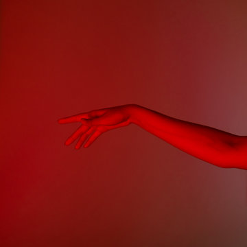 conceptual photo, elegant female hand in red light
