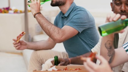 food, leisure and people concept - happy male friends drinking beer and eating takeaway pizza at rooftop party in summer