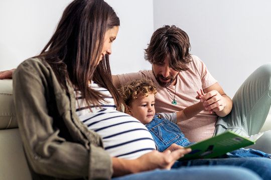 Adorable happy family reading a book at home