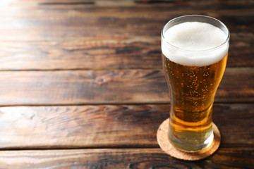 Mag with beer on wooden table, space for text