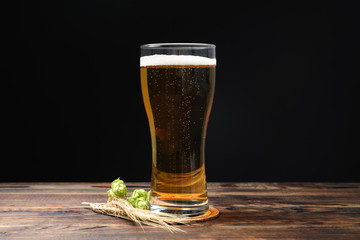 Mag with beer, spikelets and hop on wooden table, space for text