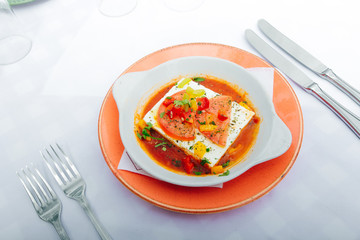Greek cheese in a sauce with tomatoes and herbs