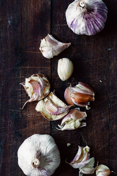 smashed garlic on a wooden board, with knife
