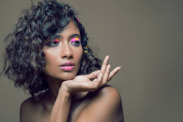 Closeup portrait of an Indian model with bold eye makeup and lipstick looking at camera. Makeup...