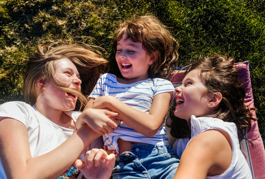 Little sisters having fun lying on the grass