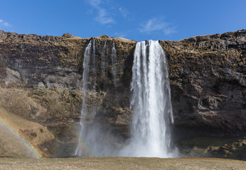A waterfall cascades over a cliff edge.