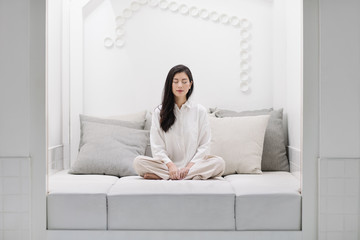 A Woman Meditating on a Bed