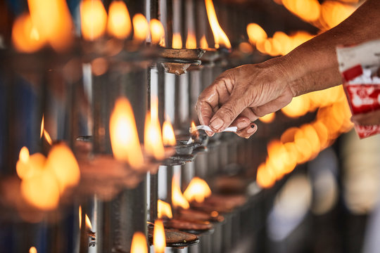 Hand lighting candle at Temple of the Sacred Tooth Relic, Kandy, Sri Lanka