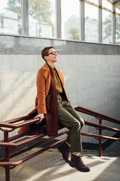 Excited woman sliding down from railing