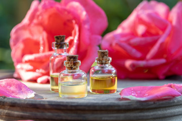 Obraz na płótnie Canvas Bottles of essential oil with rose flowers