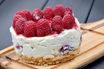 Mini cheesecake with white chocolate and raspberries on cutting board