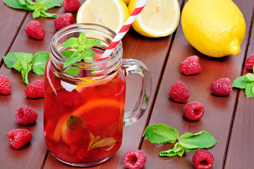 Delicious raspberries lemonade in a jar on a wooden table