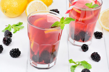 Blackberries lemonade in a glasses on wooden table