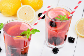 Blackberries lemonade in a glasses on wooden table