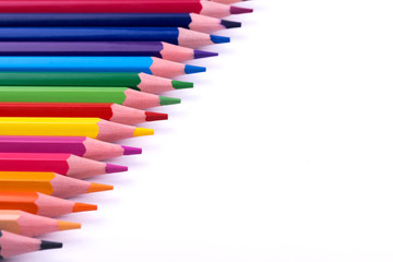 Colored sharpened wooden pencils lie on a white sheet of paper for creativity, drawing, notes, texts and letters