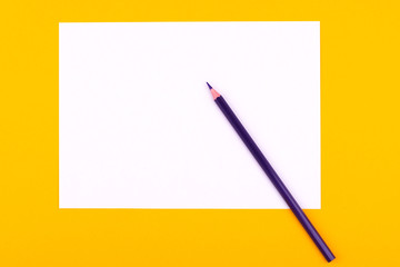 A white sheet of paper for drawings, texts and notes next to a purple pencil lies on an orange background