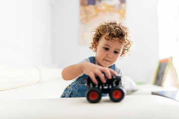 Portrait of cute baby playing with car toy
