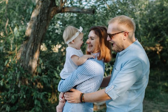 Happy family with baby girl outdoors