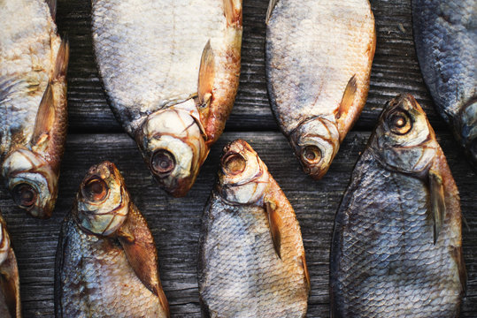 Salty dry river fish on a brown wooden background.