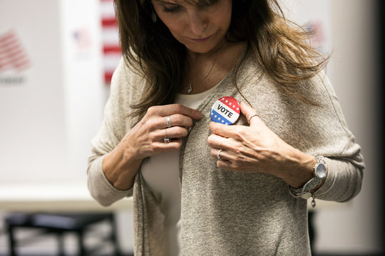 Election: Woman Pinning Button Onto Clothing After Vote