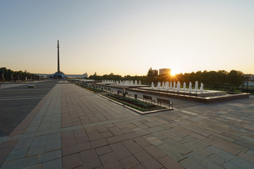 Fototapeta premium Evening Wide View of Victory Park/Park Pobedy and its fountains on Poklonnaya Hill. The city becomes calm and quiet at sunset. High angle view.