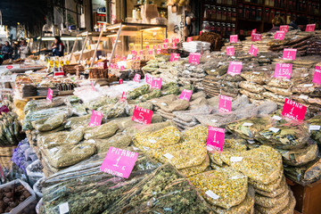 Stands with camomile, oregano and other herbs and spices with pink price tags on the Central Market of Athens.