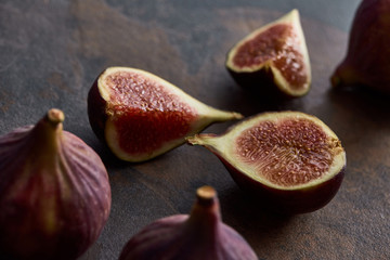 ripe whole and cut delicious figs on stone background