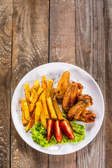 Grilled chicken wings, chips and vegetables