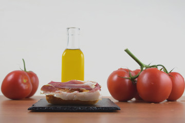 Jamon, tipico de España, con acompañamiento de aceite de oliva y tomates