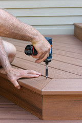 Worker Using Drill to Install Composite Wood Decking