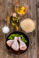 Raw chicken drumsticks on wooden background